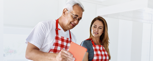 Happy couple cooking a healthy meal together to lower their cardiovascular risk