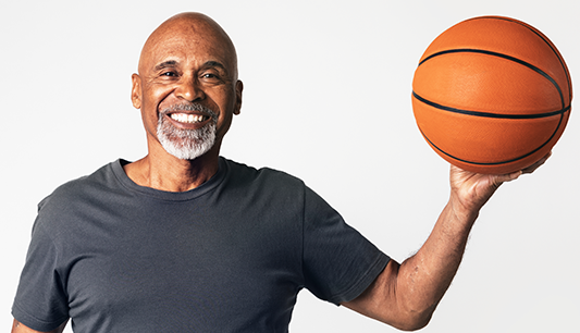 Man playing basketball to help improve his heart health